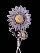 An early 20th century white metal filigree hat pin in the form of an articulated daisy: on double