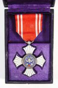 A Japanese Order of Red Cross Merit badge: silver and blue enamel with bird over red cross to one