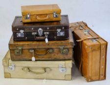 A group of seven various suitcases,: including a vellum suitcase,