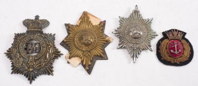Two Worcestershire Regiment pouch badges, a helmet plate and a Royal Navy cloth cap badge (4):.