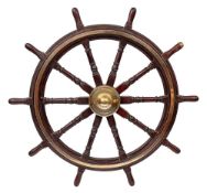 A 19th Century teak and brass ships helm:, the central iron boss with domed brass cap,