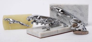 A group of Jaguar car mascots: comprising a group of four graduated mascots on a marble plinth,