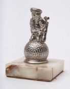 An early 20th century 'Dunlop 31' car mascot: in the form of a caddy with clubs and bag standing
