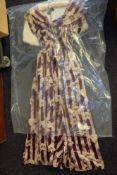 A mid 20th century silk evening dress in cream and purple with printed floral pattern: together