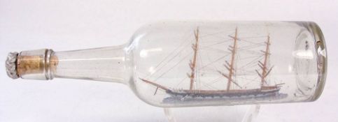 An early 20th century ship in a bottle of a waterline model of a three masted clipper: with rope