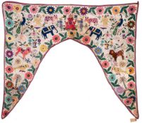 An Indian embroidered arched wall hanging: with central figure of Ganesh to the apex over birds