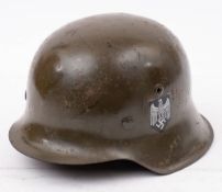 A German Model 1935 pattern steel helmet: with transfer decals, stamped '4431' to inner edge.