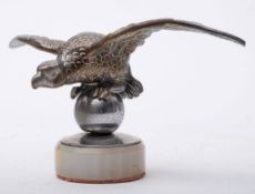 An early 20th century car mascot in the manner of Desmo modelled as an eagle on a ball:, 18cm wide.