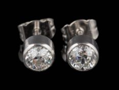 A pair of platinum and diamond single-stone ear-studs: each with a round old,