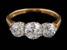 An 18ct gold and diamond three-stone ring: with round old brilliant-cut diamonds approximately 0.
