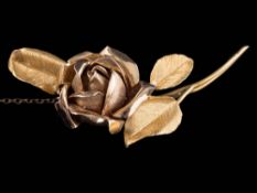 An 18ct gold 'rose' brooch: the reverse stamped 'TAD', with attached safety chain,