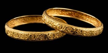 A pair of foliate engraved bangles: each approximately 60mm internal diameter,