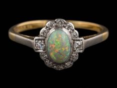 An 18ct gold, opal and diamond cluster ring: the oval opal approximately 6.5mm long x 4.