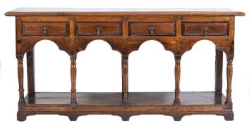 An early 18th Century oak dresser base:, the top with a moulded edge,