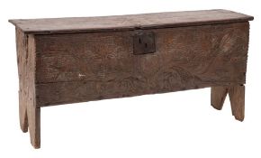 A 17th Century oak later carved plank coffer:, with incised decoration,