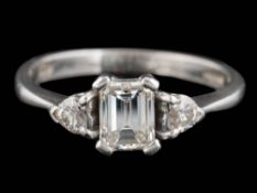 A platinum and diamond ring: with central emerald-cut diamond weighing 1.
