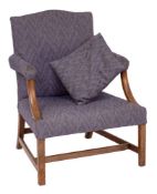 A George III mahogany library open armchair: of Gainsborough type with a stuff over serpentine back,