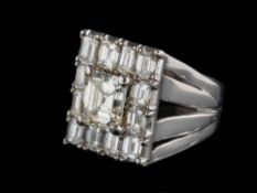 A diamond mounted rectangular cluster ring: with central emerald-cut diamond approximately 7.