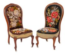 A pair of Victorian carved walnut nursing chairs: with cartouche-shield and foliate crestings,