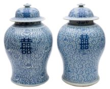 A pair of Chinese blue and white 'Shou' baluster jars and covers: painted with shou characters on a