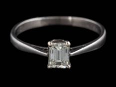 A diamond solitaire ring: the emerald-cut diamond approximately 5.0mm long x 3.9mm wide x 2.