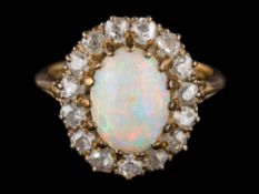 An opal and diamond oval cluster ring: the oval opal approximately 10.5mm long x 7.5mm wide x 3.