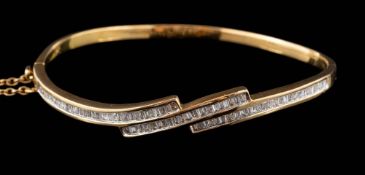 A modern diamond mounted cross-over hinged bangle: channel-set with baguette and keystone-shaped