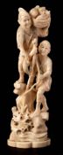 A Japanese carved ivory okimono of a fisherman : landing a fish from a rocky outcrop,