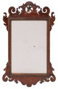 An 18th Century mahogany and partly gilt fret cut mirror:, with Ho-ho bird and shaped cresting,
