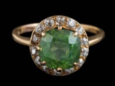 A green sapphire and diamond circular cluster ring: the cushion-shaped green sapphire approximately