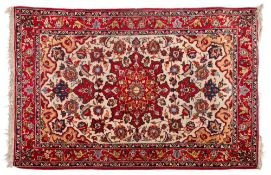 A Meshed rug:, the beige cartouche field with a central red geometric shaped pole medallion,