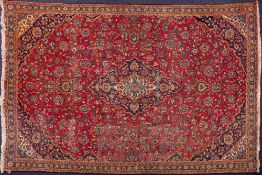 An Iranian carpet:, the red field with a central indigo lozenge pole medallion,