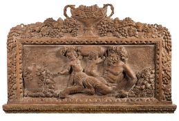 A limed and carved oak panel: decorated with Bacchus and two putti amongst wine jars and grapes,