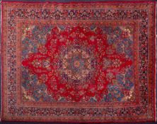 An Tabriz carpet:, the red cartouche field with a central indigo,