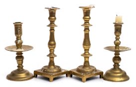 Two 18th century Continental brass candlesticks : with slender nozzles and wide circular drip trays