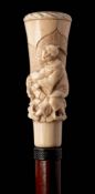 An Oriental malacca walking stick: the carved ivory handle depicting a peasant being pulled by a