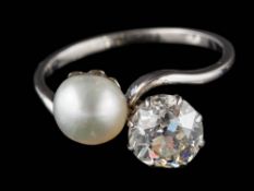 A pearl and diamond two-stone cross-over ring: the round old, brilliant-cut diamond approximately 6.