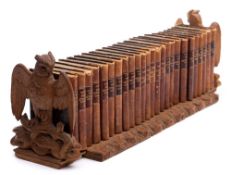 A Black Forest carved linden wood extending book stand: the ends carved as owls with outstretched