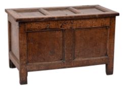 An early 18th Century oak rectangular coffer: of panelled construction with a hinged triple panel