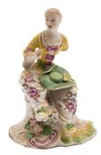 A Derby figure of a seated lady: wearing a puce trimmed yellow bodice,