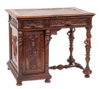 A late 19th Century Italian carved walnut kneehole desk: of broken outline,