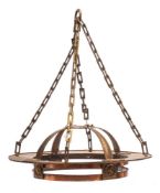 An Arts and Crafts copper light fitting: the circular corona suspended from rectangular linked