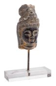 An Indo Persian carved stone head: wearing a traditional headdress, the head 14cm. high.