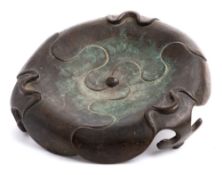A Chinese bronze tripod stand: of petal-shaped form with ruyi-head feet, Qing, 18cm wide.