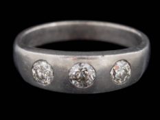 A platinum and gypsy-set diamond three-stone ring: with circular,