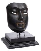 An Egyptian bronze mask: mounted on a stepped ebonised wood base, the mask 16.5cm.
