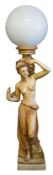 A resin figural floor standing lamp of a semi-naked slave girl: holding a cornucopia shell on her