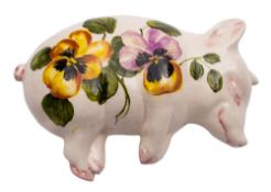 A pair of Exon Ware Wemyss pottery sleeping pigs: one painted with oranges and foliage the other