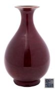 A Chinese sang-de-boeuf bottle vase: the globular body and flared rim covered in a rich oxblood