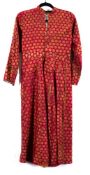 A 19th Century Indian silk longcoat: with all over flowerhead decoration to a red ground.